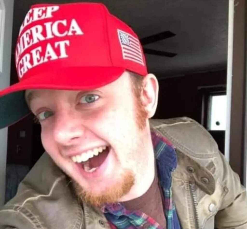 smiling selfie of luke wenke wearing a "keep america great" hat and sitting in a vehicle